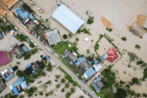 Aerial view of flooded residential area with submerged houses and roads, highlighting the impact of natural disasters like floods on communities and the importance of sustainable building practices.
