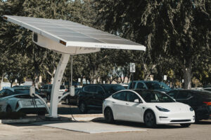 ev Electric vehicle charging station with solar panels and a white EV parked nearby, highlighting sustainable energy solutions for electric vehicles.