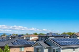 Sunny residential neighborhood with homes showcasing installed solar panels under a clear blue sky